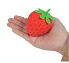 Holding a red strawberry-shaped TheMoodease stress ball in one hand, light and portable to carry.
